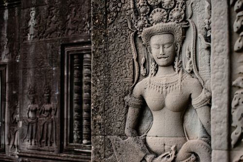 Free Detailed stone carvings of Devata figures at Angkor Wat in Cambodia. Ancient Khmer architecture. Stock Photo