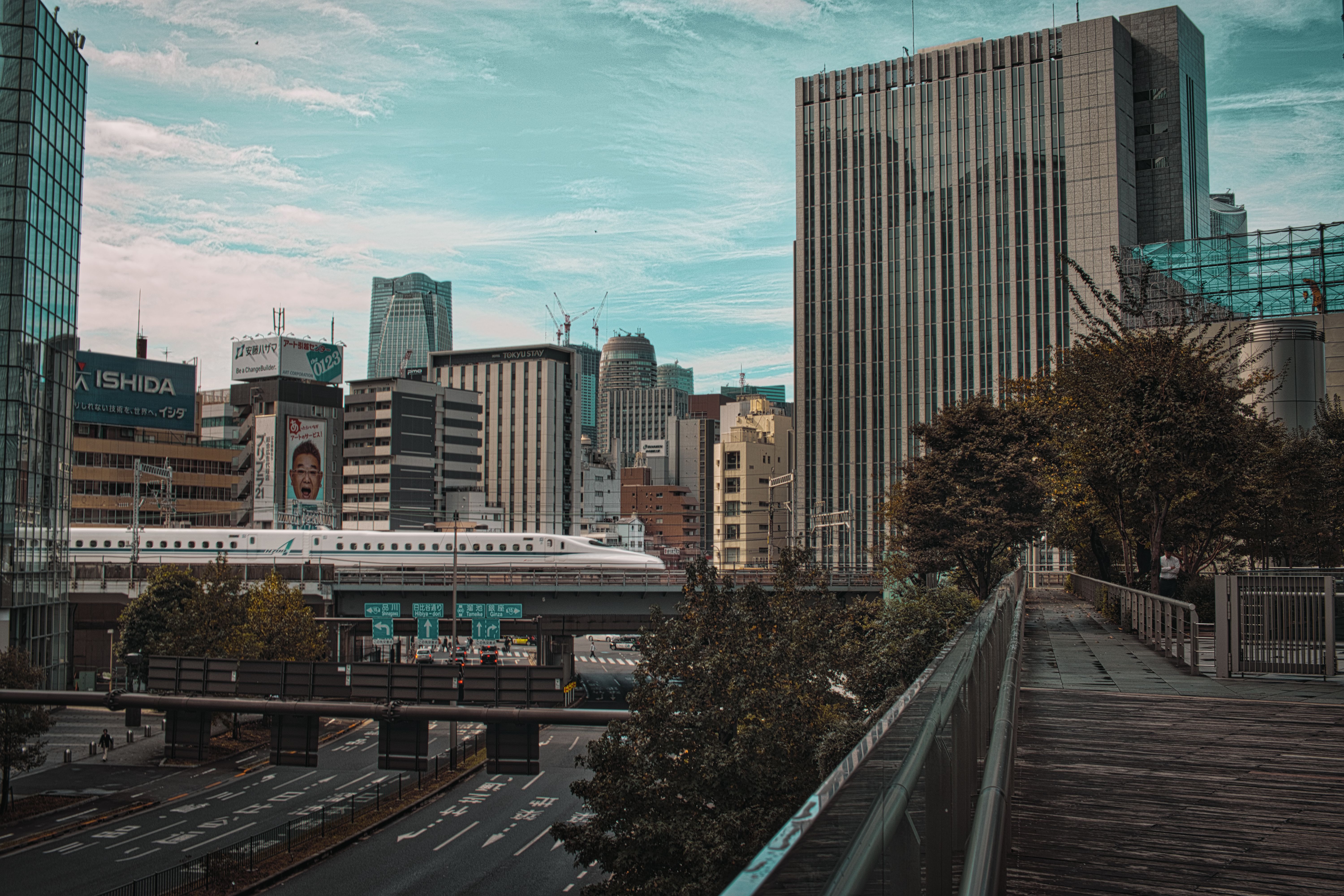 Panoramic view of Tokyo's Minato City featuring a bullet train passing amidst modern skyscrapers.