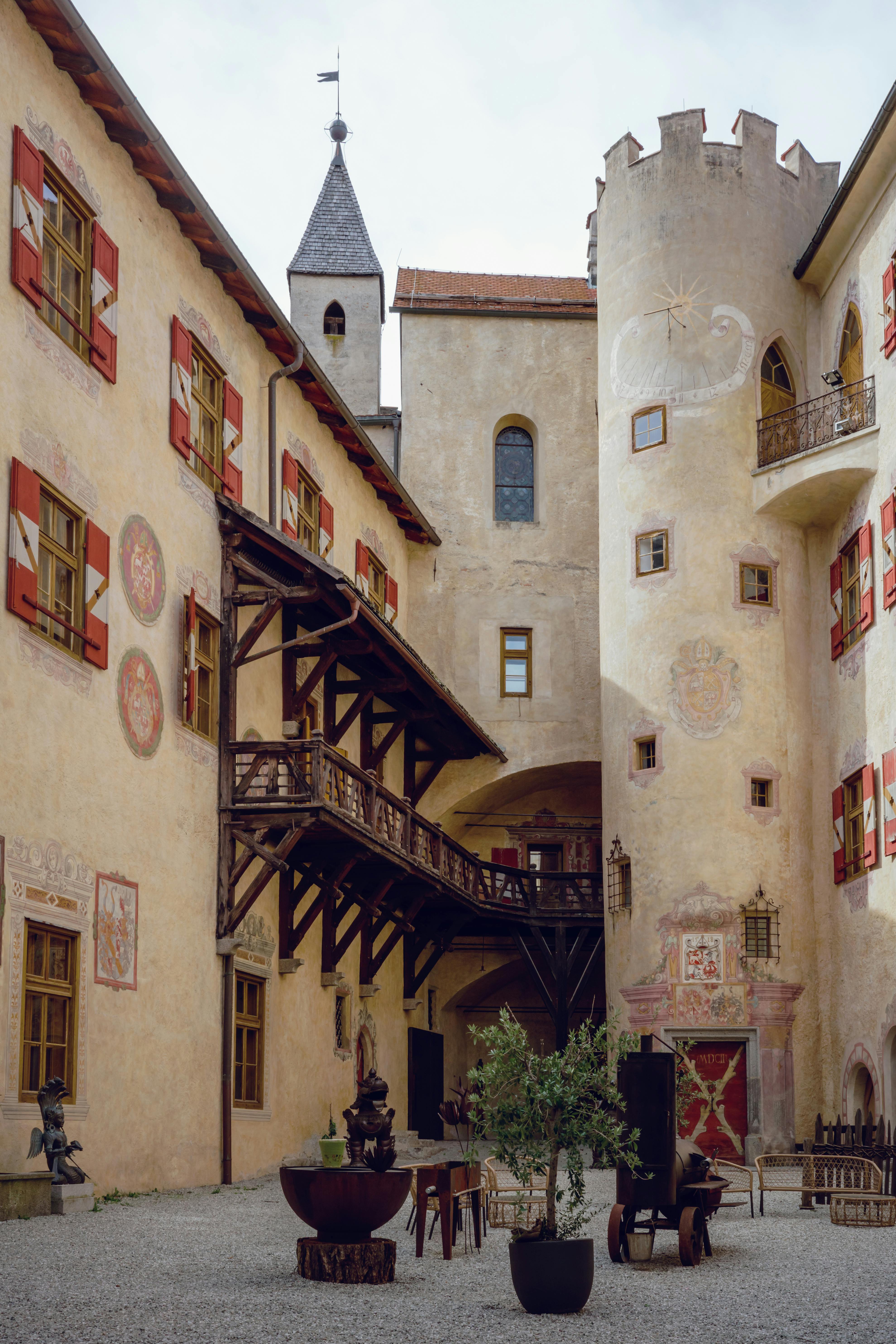 Charming courtyard of a historic medieval castle featuring unique art and architecture.