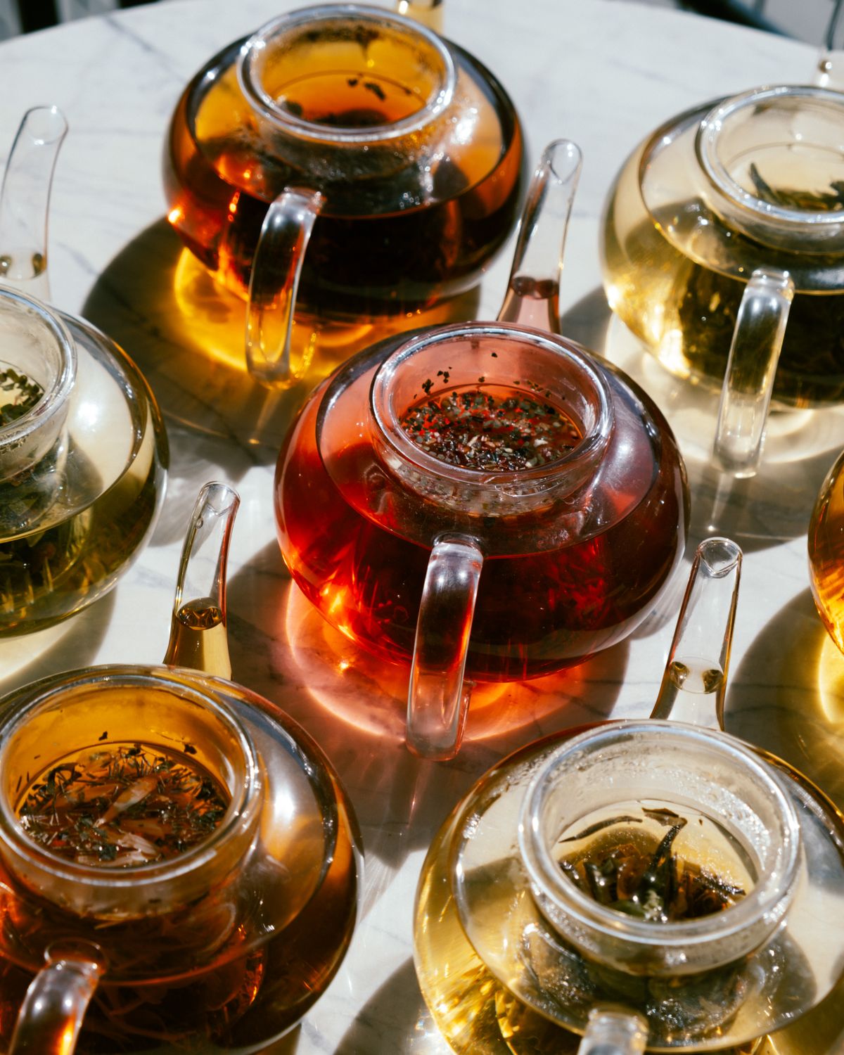 A refined assortment of herbal infusions in clear glass teapots