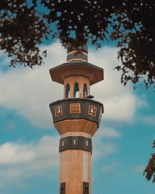 Free Stunning view of a mosque minaret framed by trees, showcasing intricate Islamic architecture. Stock Photo