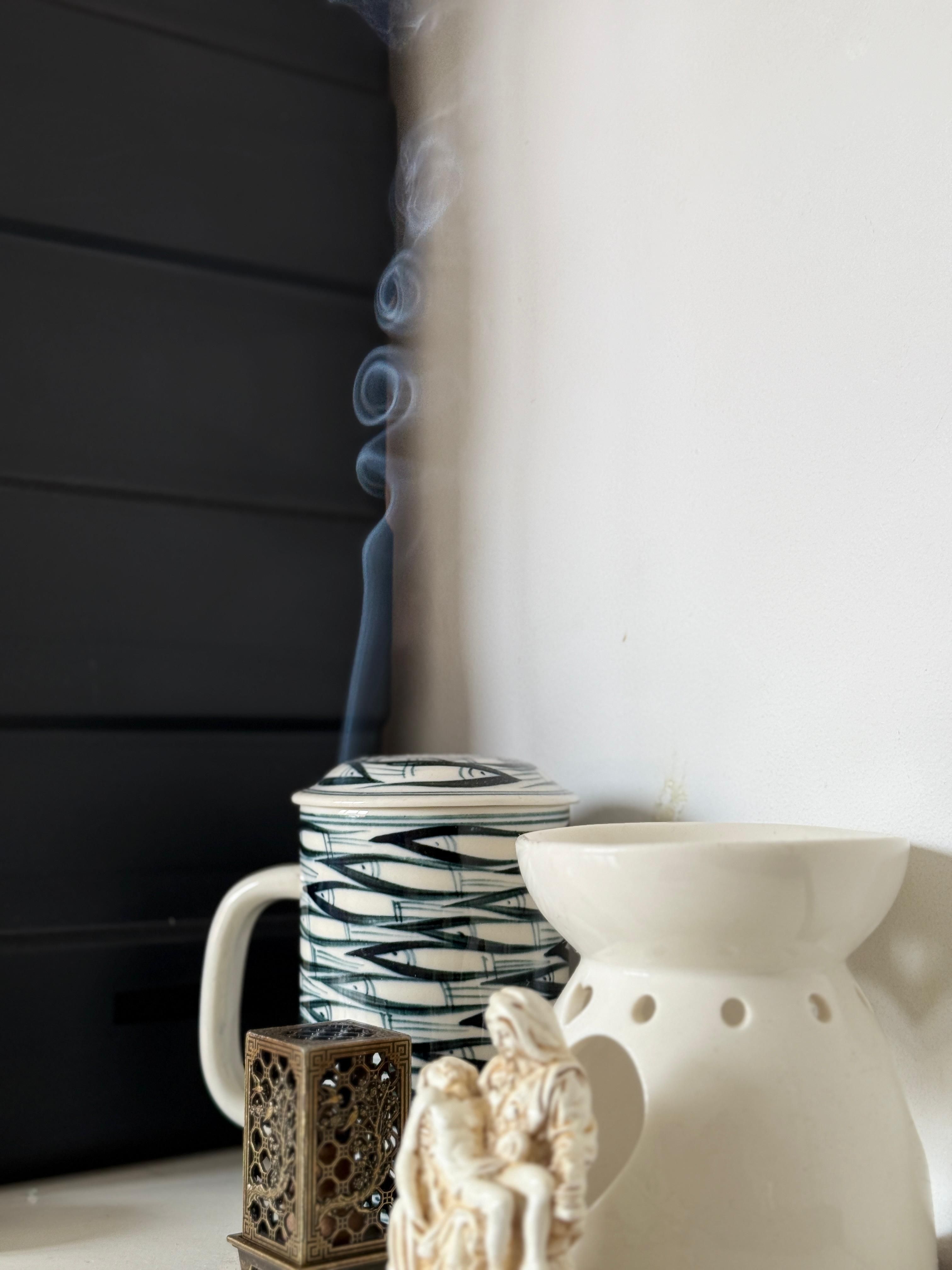 A still life composition of incense burning, creating elegant smoke patterns in a tranquil setting.