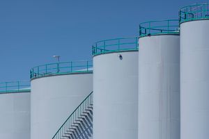 Refinery storage tanks with green railings under a clear sky — photo by Jan van der Wolf on Pexels