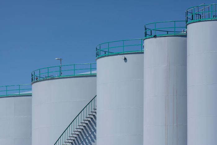 Large industrial storage tanks against a blue sky