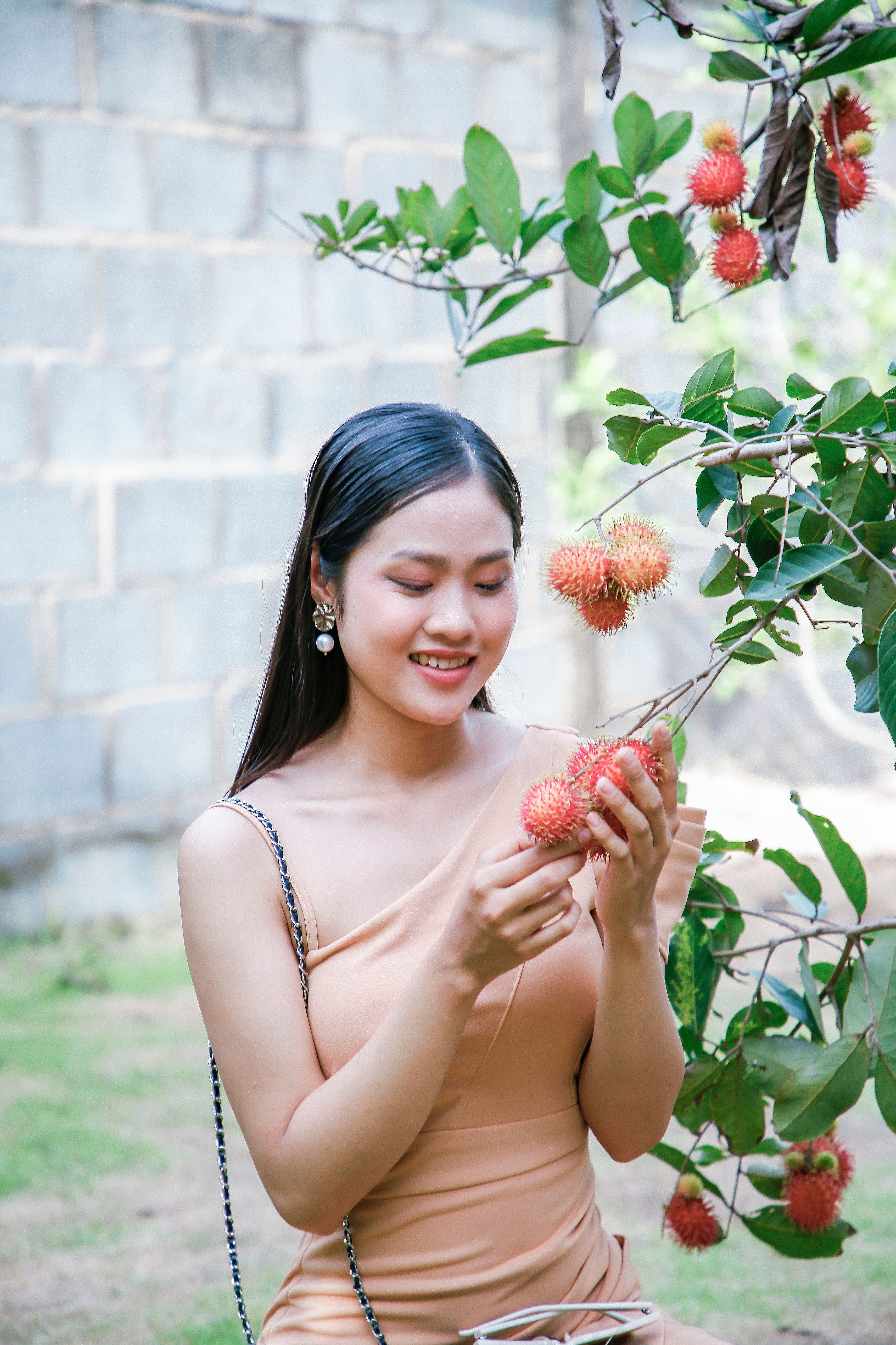 Woman Enjoying Fresh Rambutan Fruit From Tree · Free Stock Photo