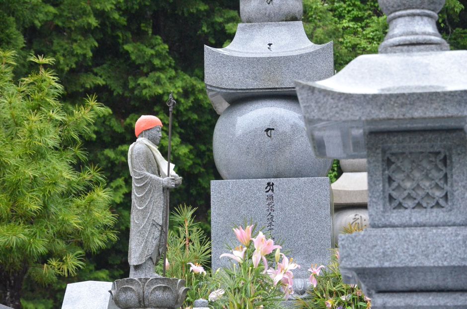 伝統的な彫像と豊かな緑に囲まれた、日本の高山にある墓地の静かな風景。