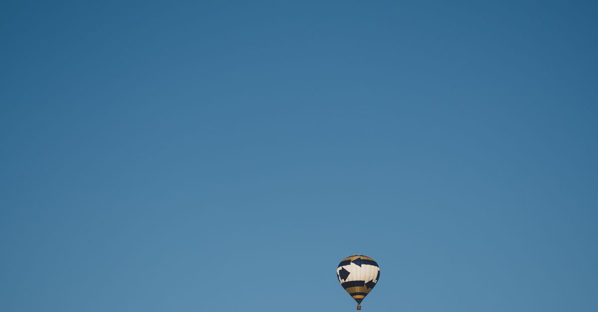 Rüyada Gökyüzünde Asılı Kalmak - Rüya Tabiri ve Anlamı - A serene hot air balloon floats beneath a clear sky with a visible moon in Columbia, Missouri.