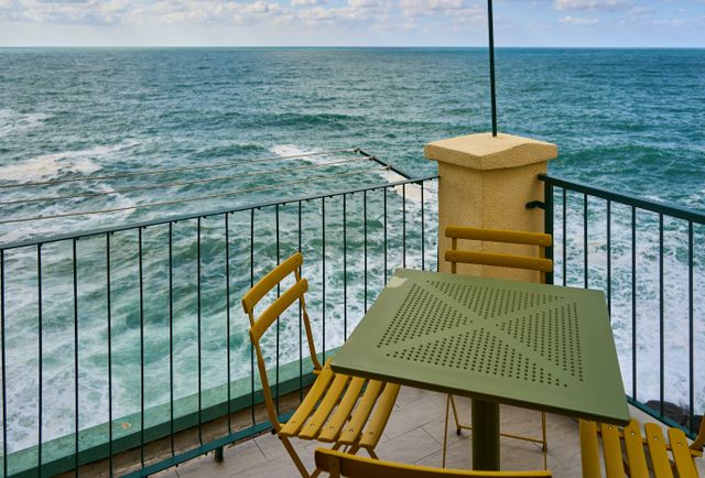 Terrasse en bord de mer avec chaises et table face à l'océan