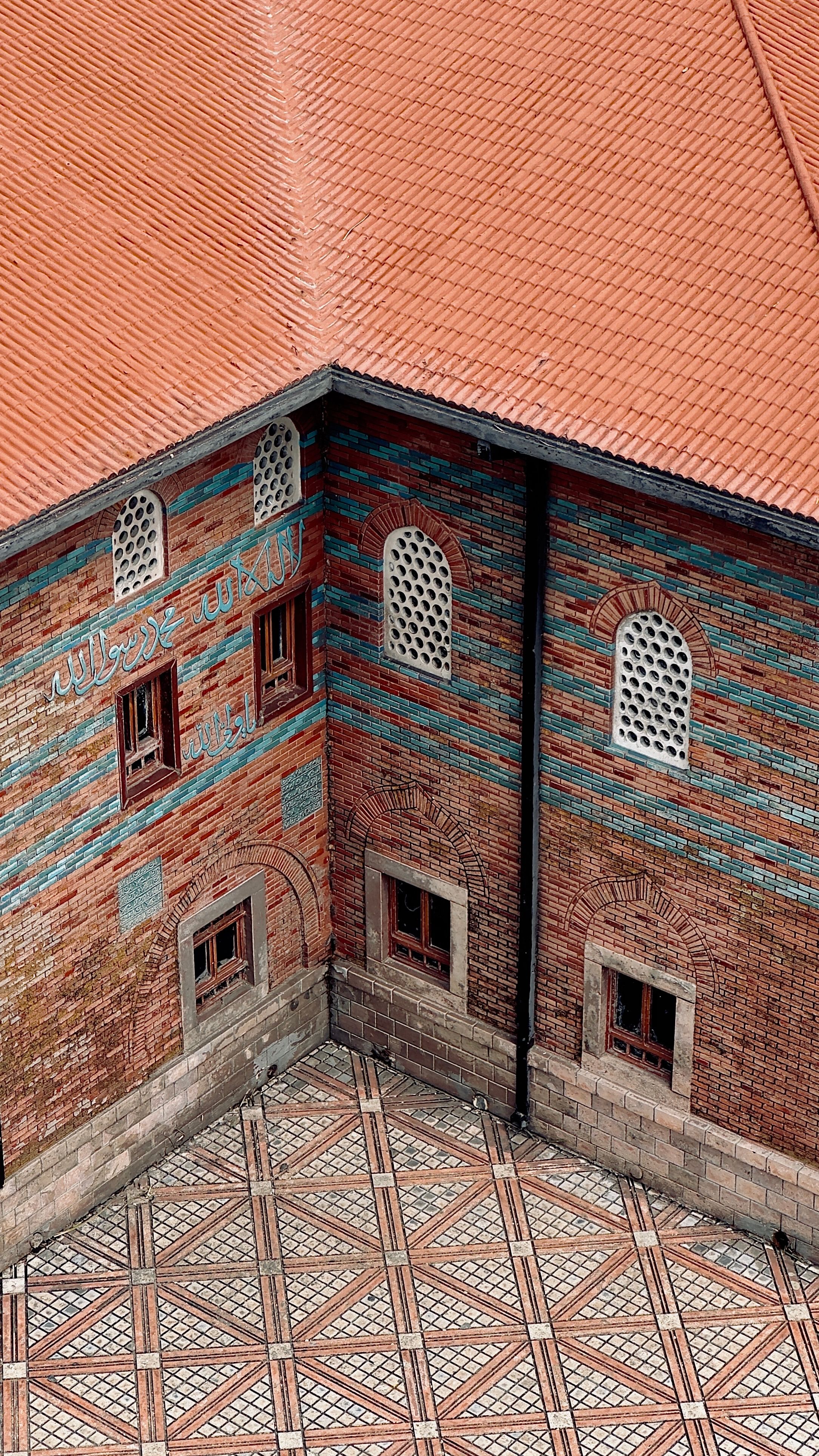 Aerial view of a traditional Ottoman building with a distinctive red tiled roof and ornate windows.