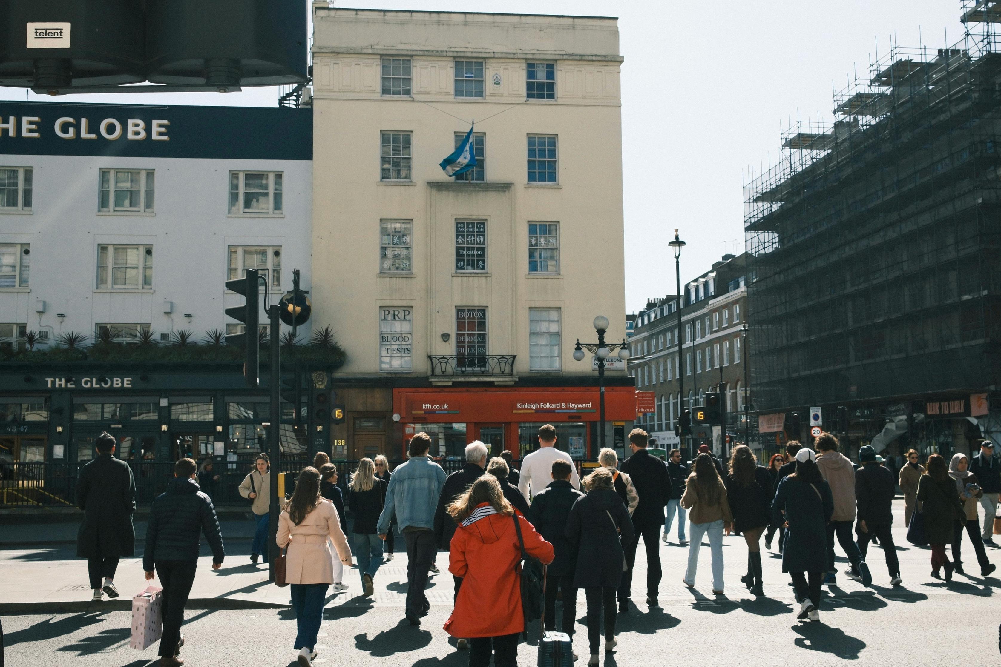 Urban scene in London with a diverse group of people crossing the street.