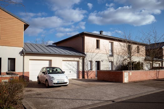 Modern suburban house with parked car in sunny Compiègne, France street.
