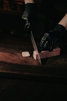 A chef slices fresh wagyu beef with precision on a wooden board, showcasing culinary excellence.