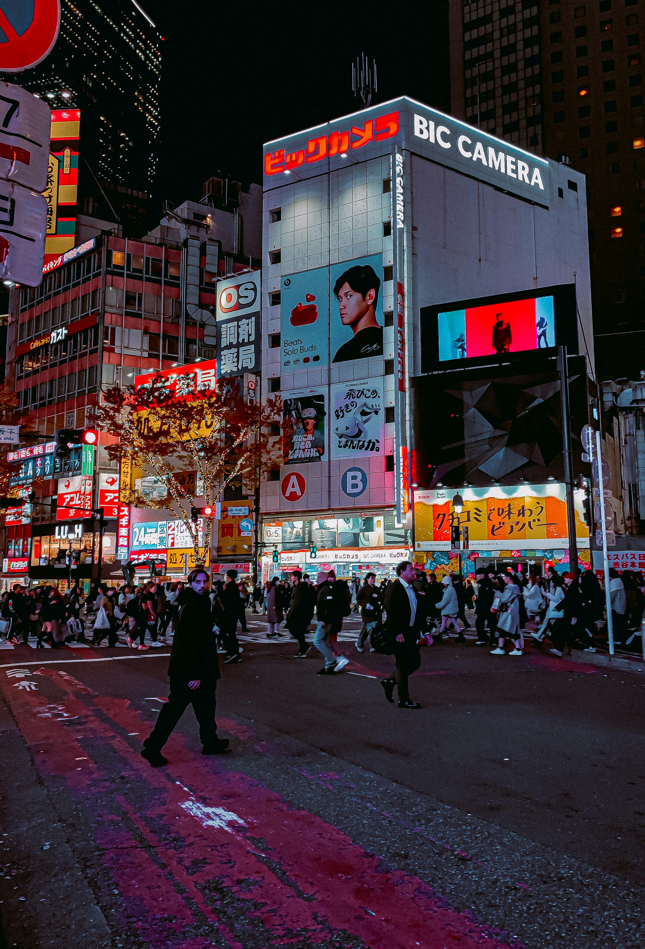 Crowds crossing the iconic Shibuya Crossing at night in Tokyo