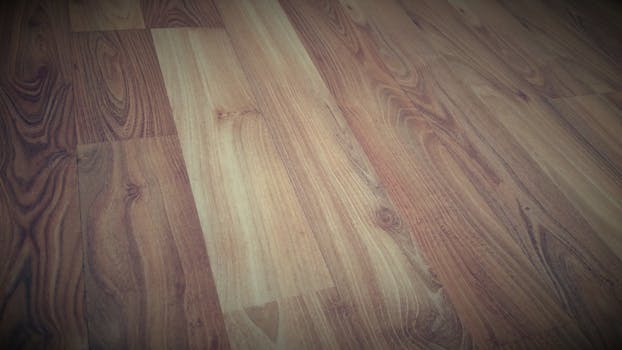 Close-up of a wooden floor showcasing a rich brown grain pattern with a rustic texture.