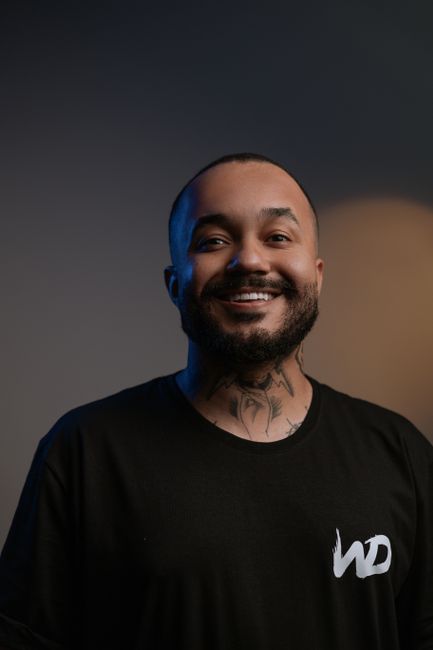 Fotomural Hombre feliz con barba y tatuaje sonriendo en retrato de estudio