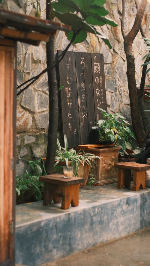 Free Peaceful garden setting with wooden stools and lush greenery, ideal for relaxation. Stock Photo