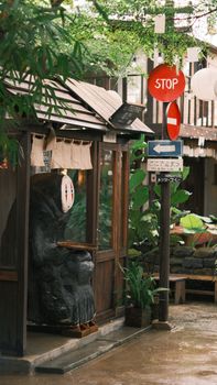 A quaint street corner with traditional architecture, lush greenery, and vibrant signage creates a warm, inviting scene.