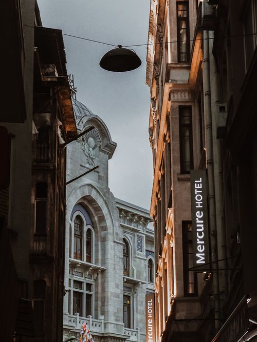 Free View of a narrow urban street featuring historical and modern architecture. Stock Photo