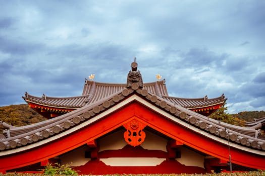 Beautiful shot of a traditional Japanese temple roof with intricate design under a cloudy sky.
