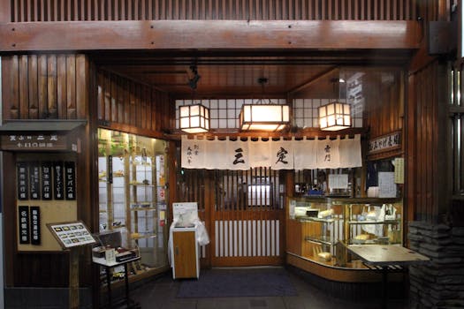 Entrance of a traditional Japanese restaurant with wooden decor and display case, offering an inviting atmosphere.