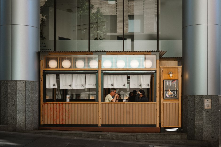 A small ramen shop on a busy Melbourne street offers a warm and inviting dining experience.