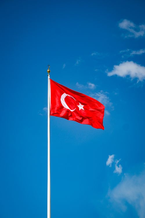 Free The national Turkish flag waving against a clear blue sky in Ankara, Türkiye. Stock Photo