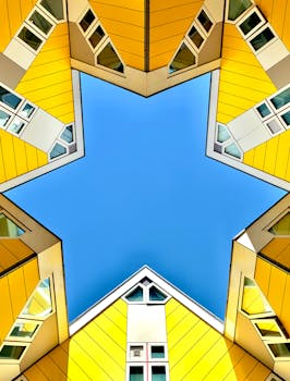 Star-shaped view of yellow cube houses against a clear blue sky.