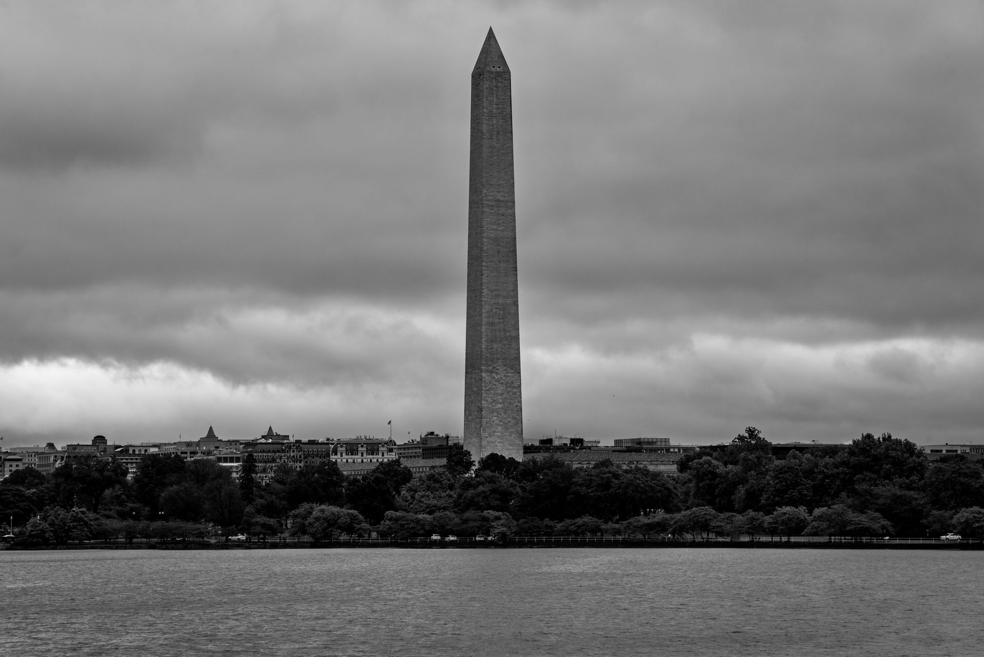 Granite obelisk standing in a park on an overcast morning