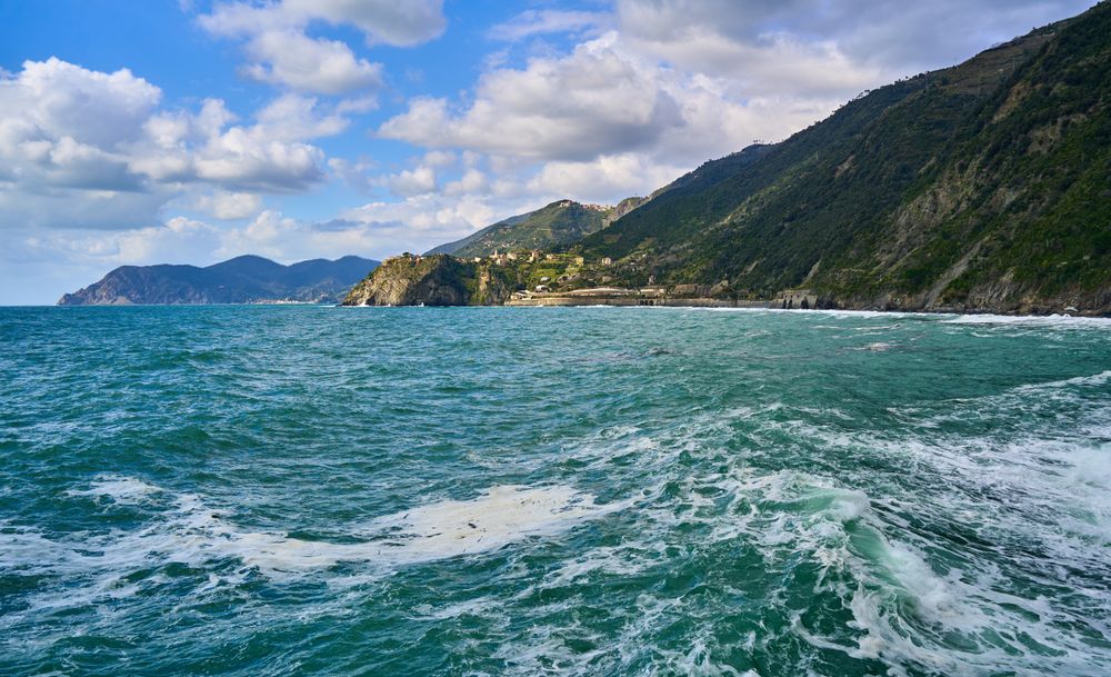 Coastă ligurică cu mare turcoaz și dealuri verzi