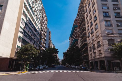 Free Wide-angle view of a street in Buenos Aires with tall buildings and clear sky. Stock Photo