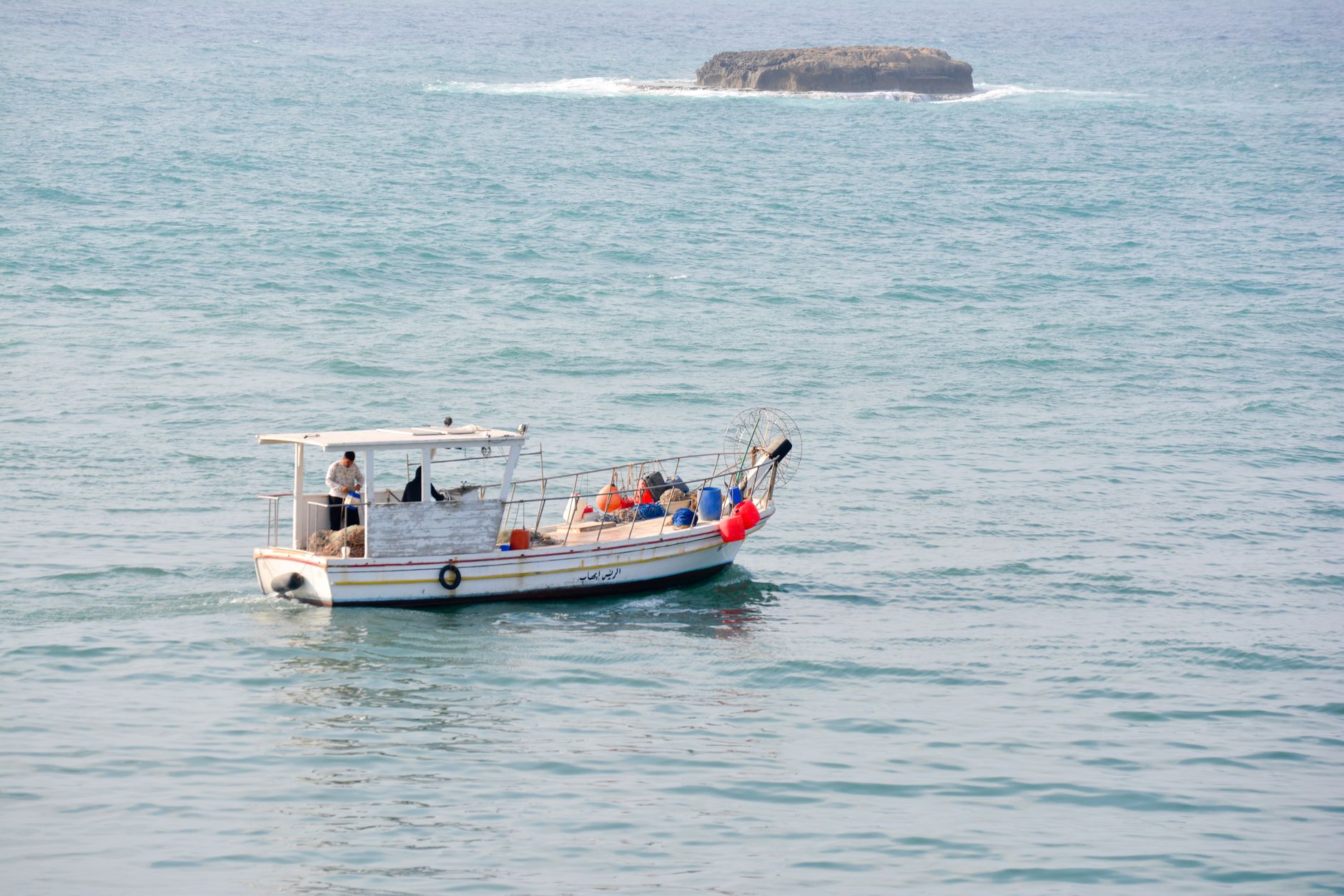 Small boat with life vests cruising near Sidon coastline, Lebanon.