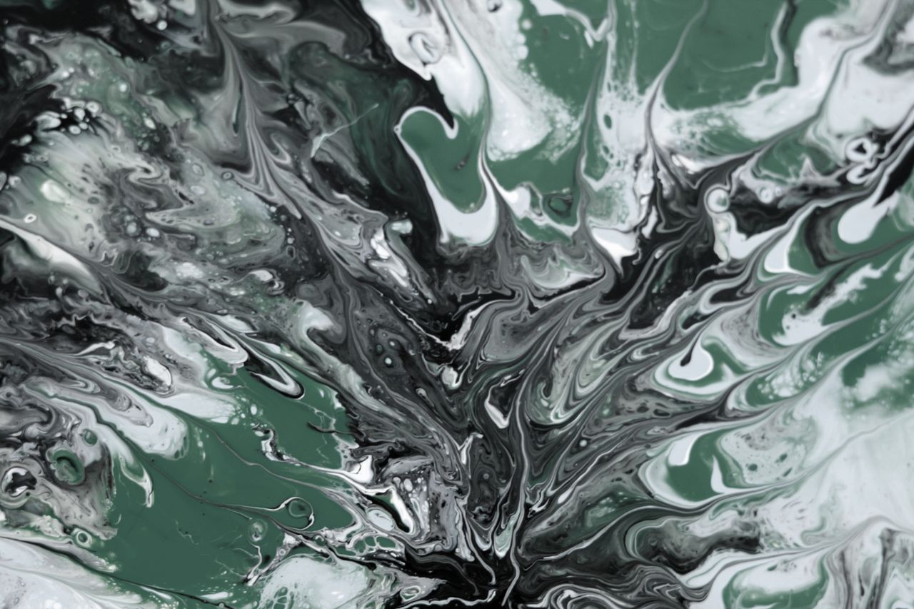 fluid art featuring intricate green and black swirls creating a mesmer