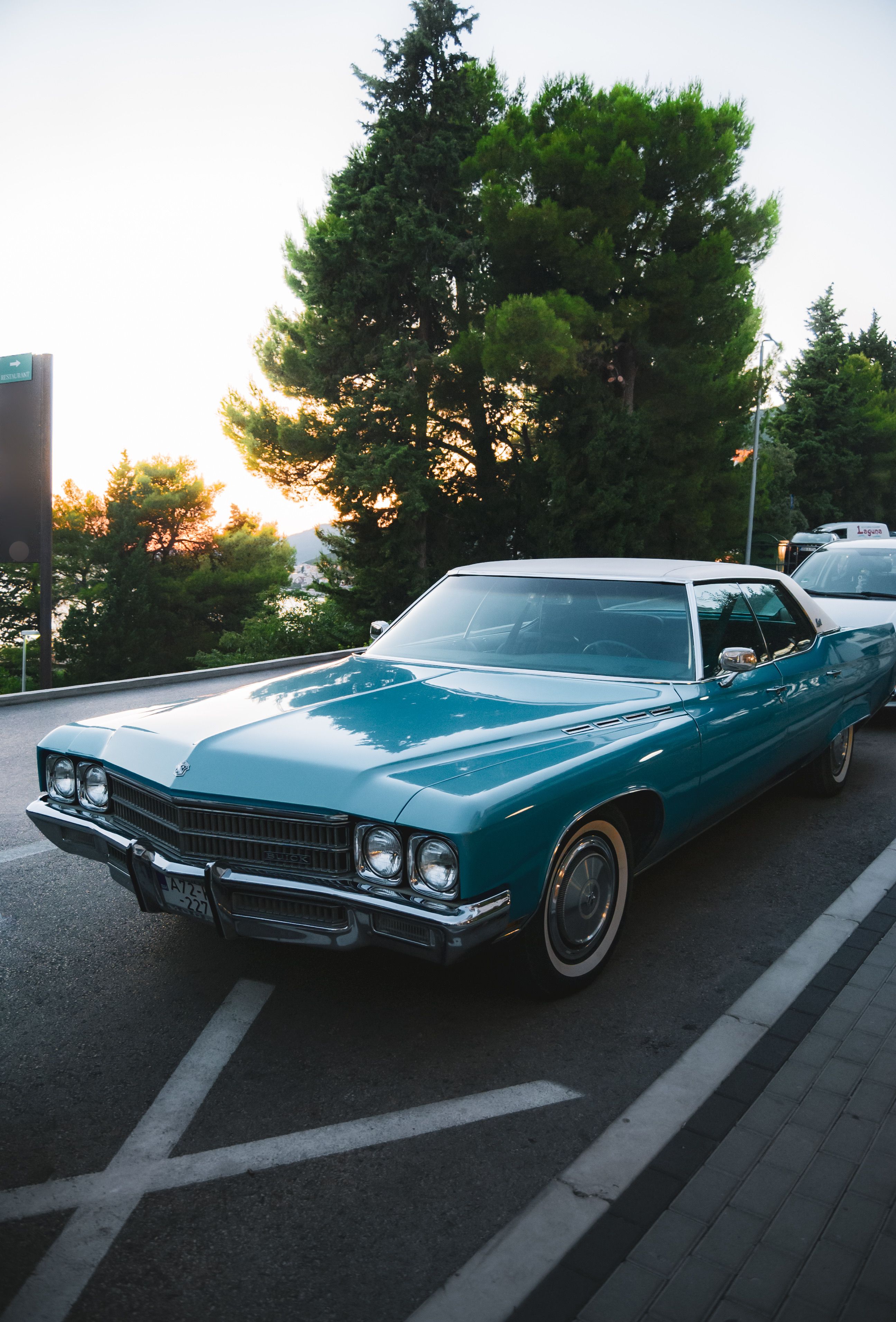 Vintage Blue Classic Car on Scenic Road at Sunset · Free Stock Photo