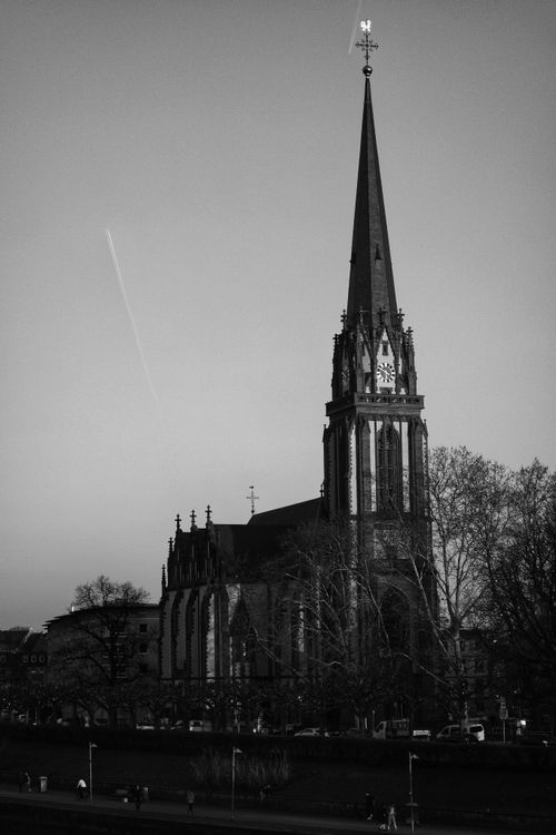 Free A striking black and white photo of a Gothic church tower with an airplane contrail in the sky. Stock Photo