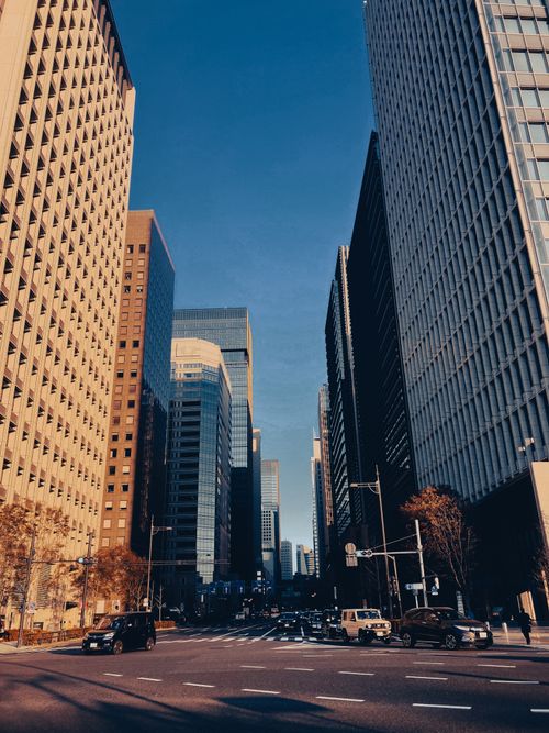 Free Urban street view of high-rise buildings on a clear day, showcasing modern architecture and bustling city life. Stock Photo
