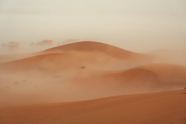 Red dunes wrapped in fog. Photo by Denys Gromov on Pexels