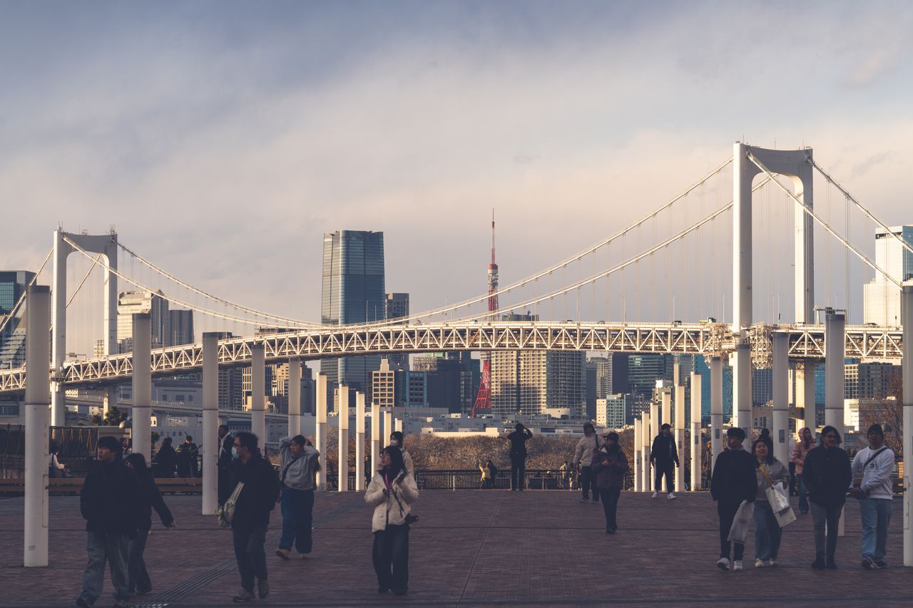 beautiful sunset view of rainbow bridge and tokyo skyline with people