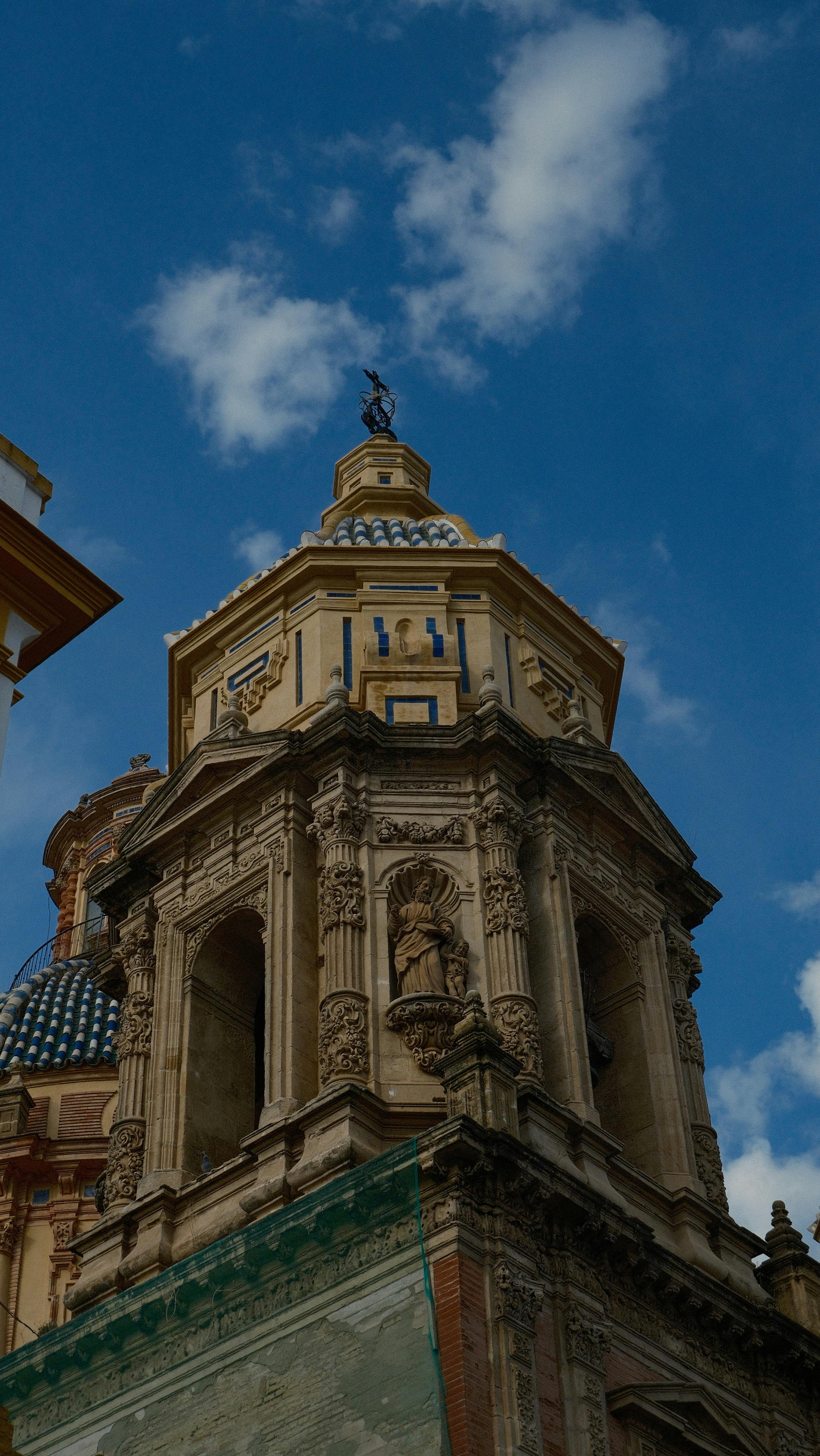 Intricate architecture of San Telmo's dome in Seville under a bright blue sky.