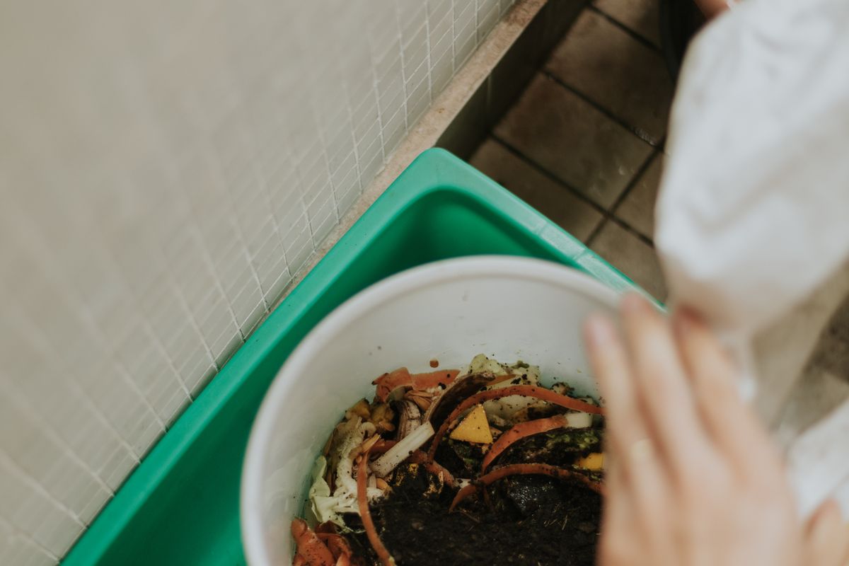 Adding food scraps to a compost bin