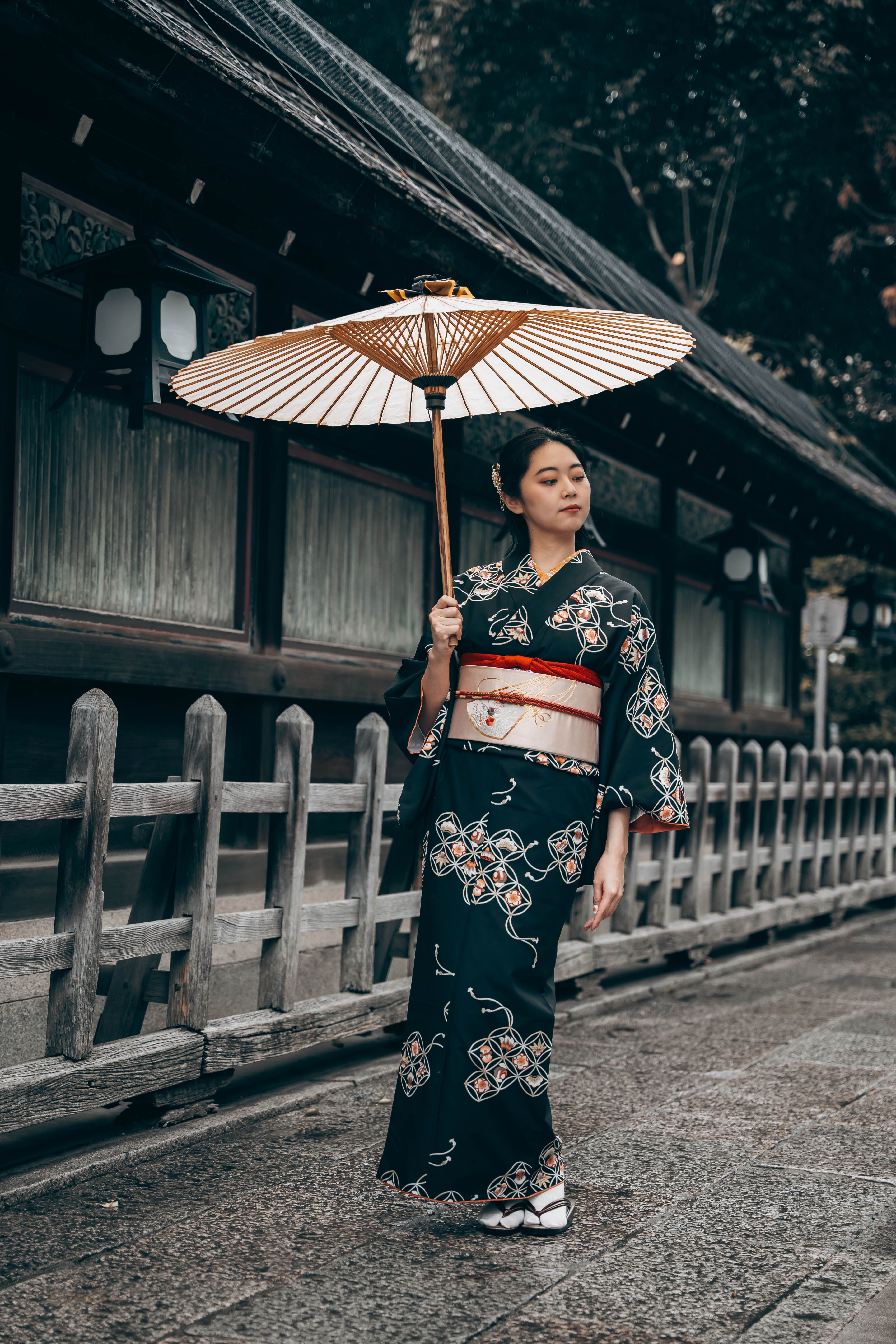 Japanese woman in kimono with umbrella at Kyoto temple.