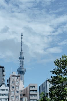 A view of the Tokyo Skytree amidst modern buildings under a clear blue sky.