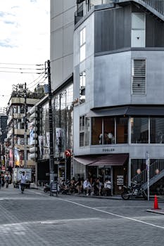 Contemporary urban scene featuring people at a modern building in a bustling city street.