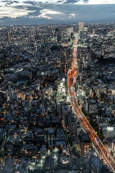 Stunning aerial view of Tokyo's illuminated cityscape at night, capturing vibrant urban life.