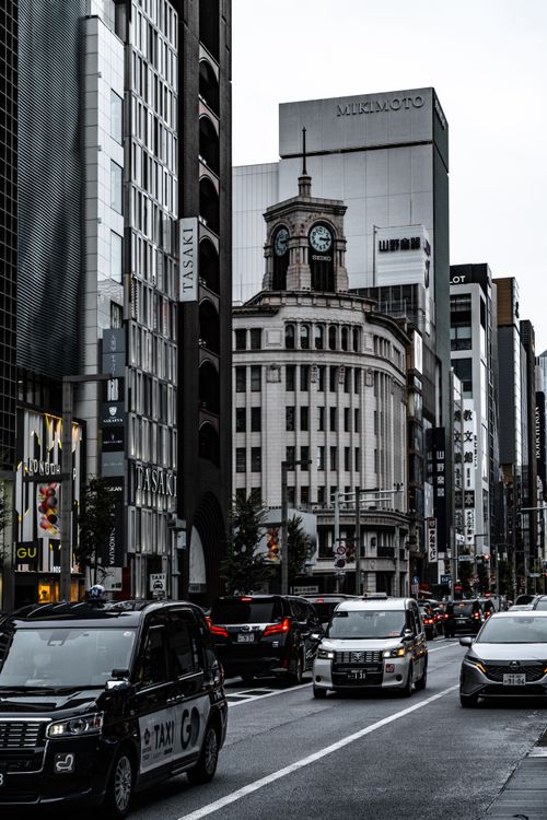 Free Bustling street in Ginza, Tokyo featuring the iconic Wako clock tower and bustling traffic. Stock Photo