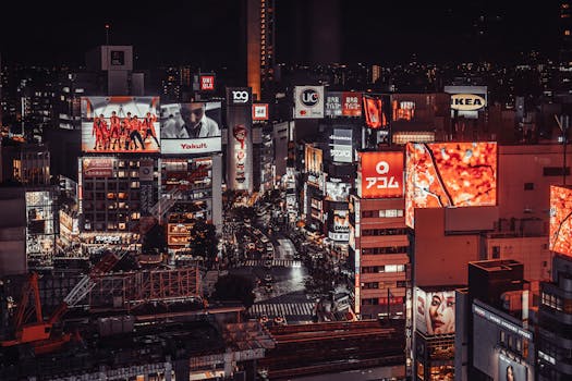 Vibrant night scene of Shibuya, Tokyo with illuminated billboards and busy streets.