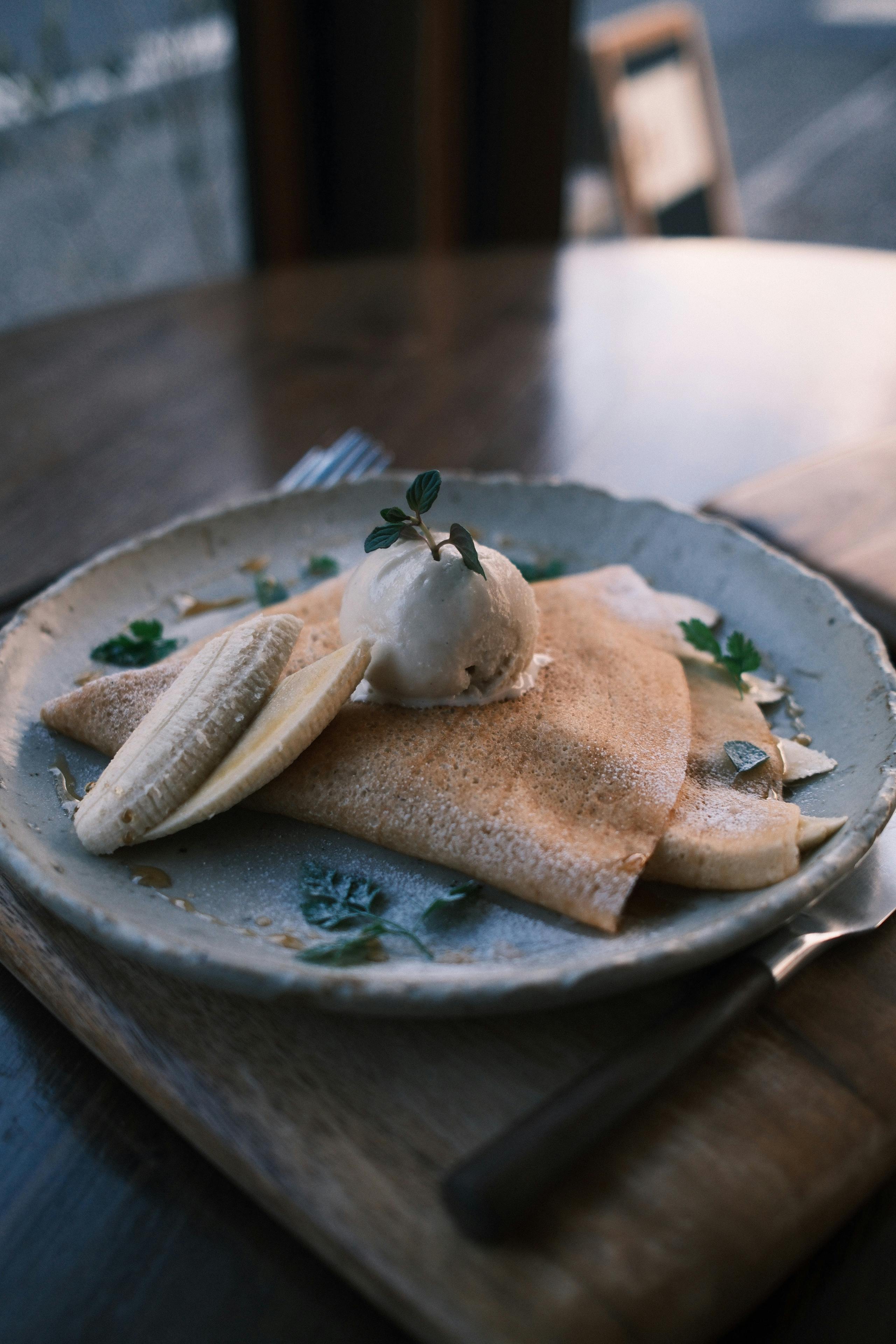 Savor this elegant banana crepe topped with ice cream, beautifully served at a cozy cafe in Nikko, Japan.