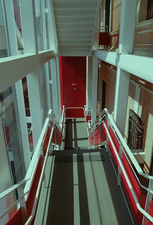 Free A sleek, modern staircase with red accents and abundant natural light illuminating the space. Stock Photo