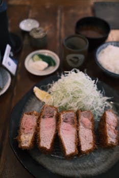 Crispy tonkatsu served with shredded cabbage, rice, and dipping sauce, capturing the essence of Japanese cuisine.