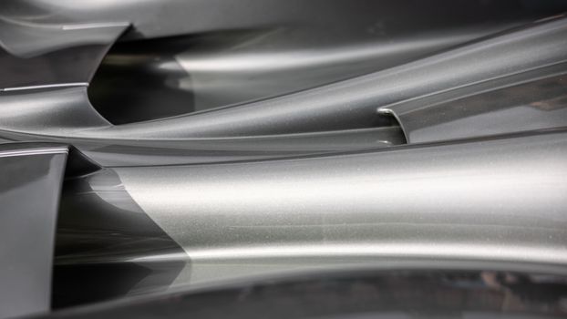 Close-up of sleek abstract metal surfaces with smooth curves and reflections.