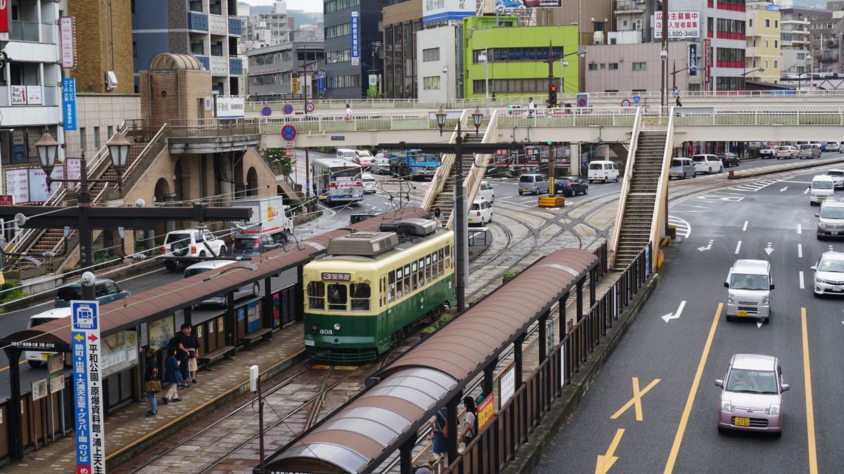 Busy Nagasaki city street with tramway and overpass